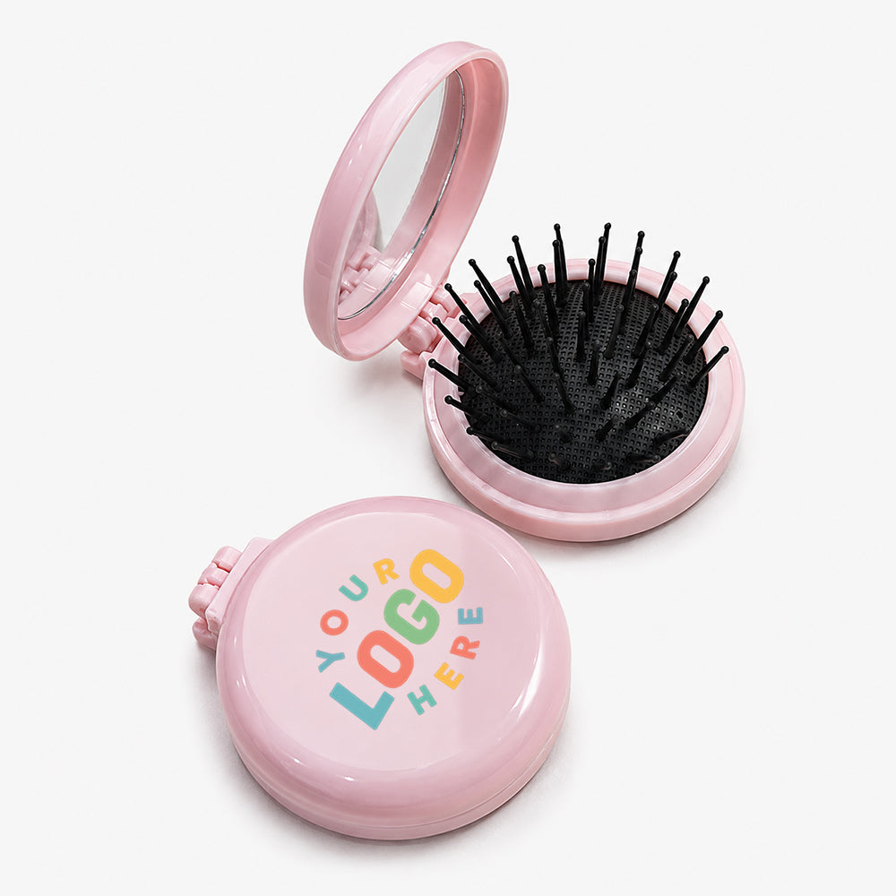 Pink folding hair brush with built-in mirror, black bristles, and compact circular design