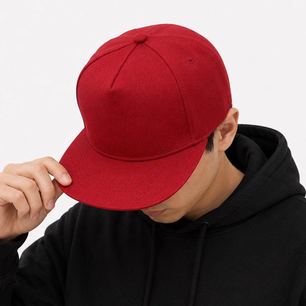Red five-panel snapback cap with flat brim and structured crown worn by a person