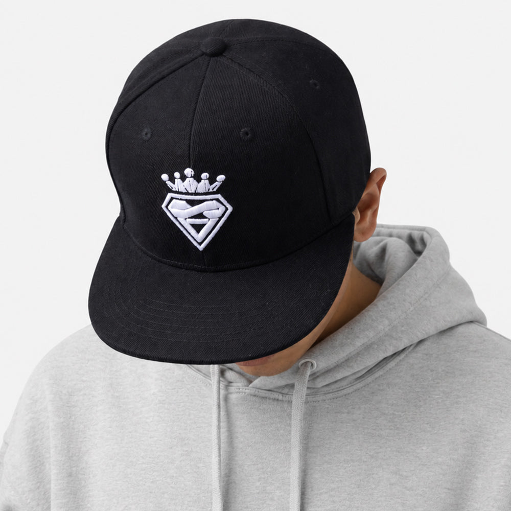 Black six-panel snapback cap with flat brim and white embroidered crown-and-shield design on front