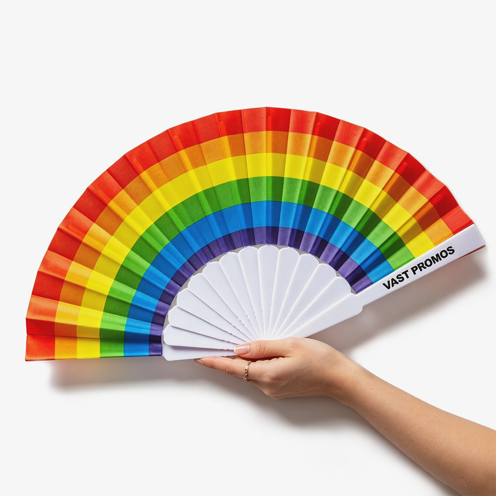 9-Inch Fabric Folding Hand Fans with vibrant rainbow stripes, white plastic ribs, held by a hand against plain white background