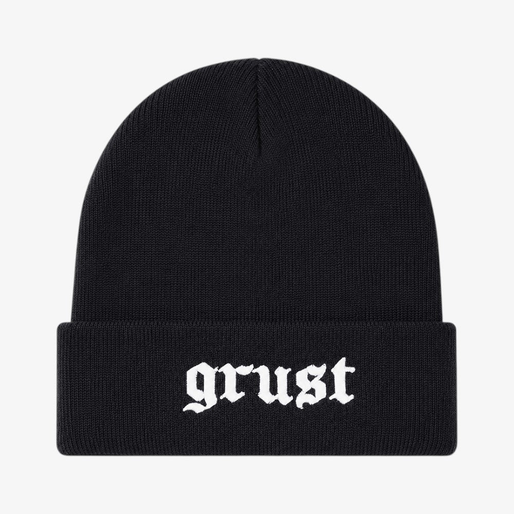 Black knit beanie with a folded cuff and white gothic-style embroidered text