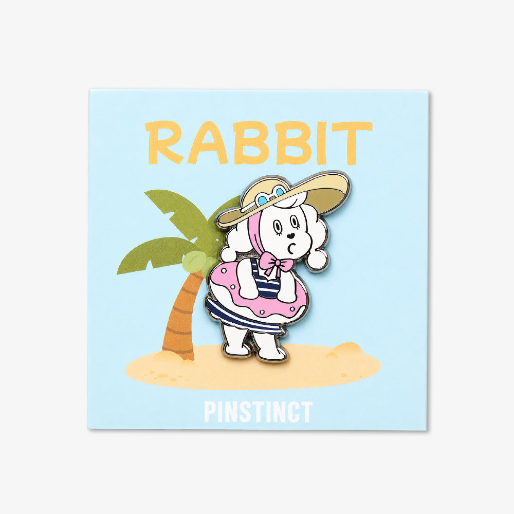 Enamel pin of a white rabbit in a pink life ring and striped outfit, wearing a wide-brimmed hat beside a palm tree