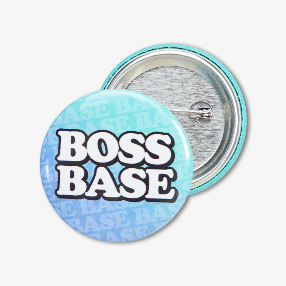 Button badge with light blue gradient "BOSS BASE" print, showing front design and metal pin backing