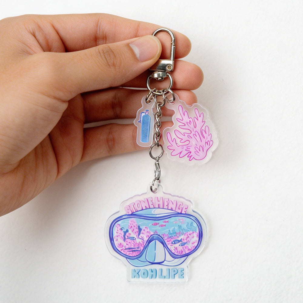 Custom acrylic keychains with cute ocean diving design, held in hand, decorated with small coral and scuba tank charms