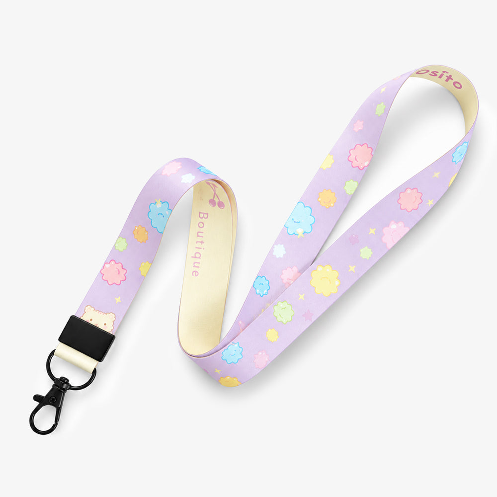 Soft purple lanyard with pastel cloud and star patterns, black clip, and cream-colored backing