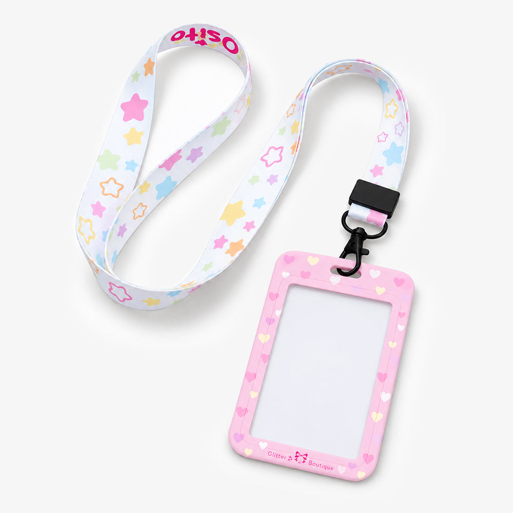 Pink heart-patterned ID badge holder attached to a white lanyard with pastel star prints and a black clip