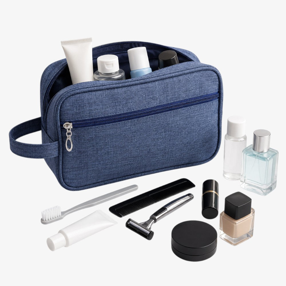 Navy blue fabric toiletry bag with zipper closure, top handle, and visible interior compartments holding travel-sized items