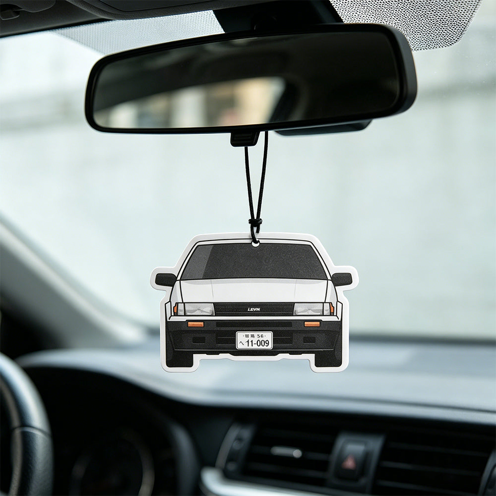 Hanging air freshener in cartoon vintage sedan shape, hung on car rearview mirror inside the vehicle