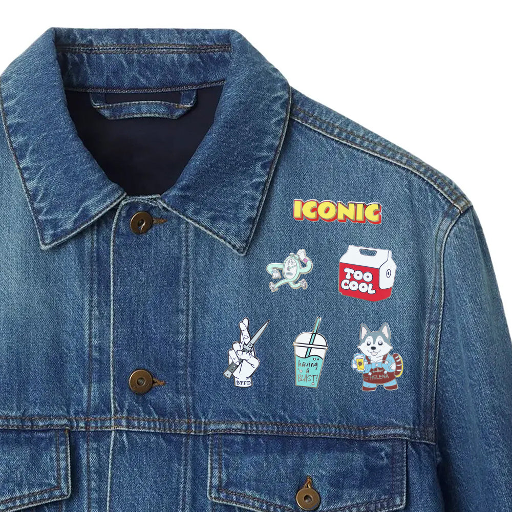 Hard enamel pins in various fun cartoon designs attached to a blue casual denim jacket