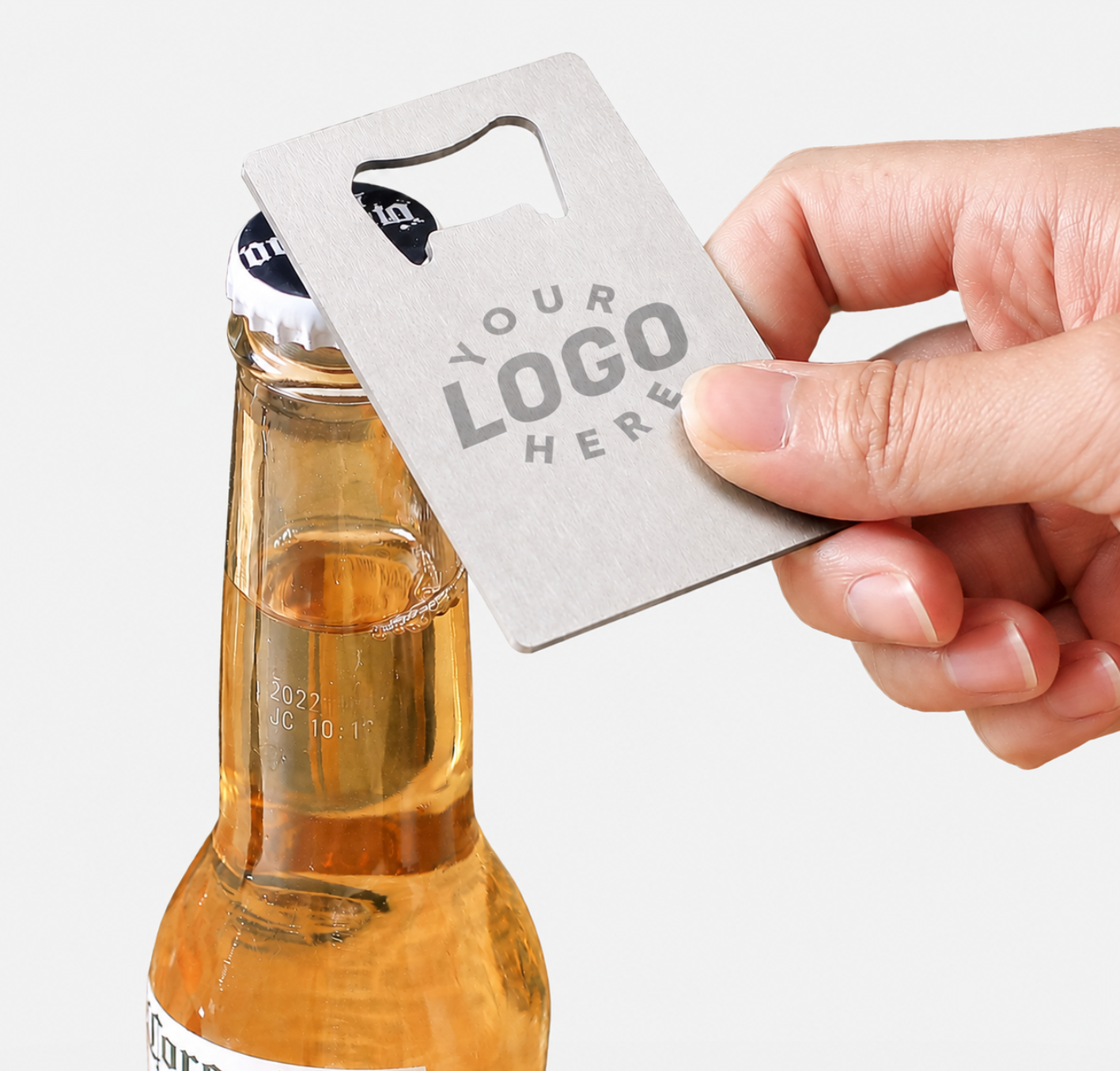 Metal credit card bottle opener with custom logo space, used to pry open a glass beer bottle cap