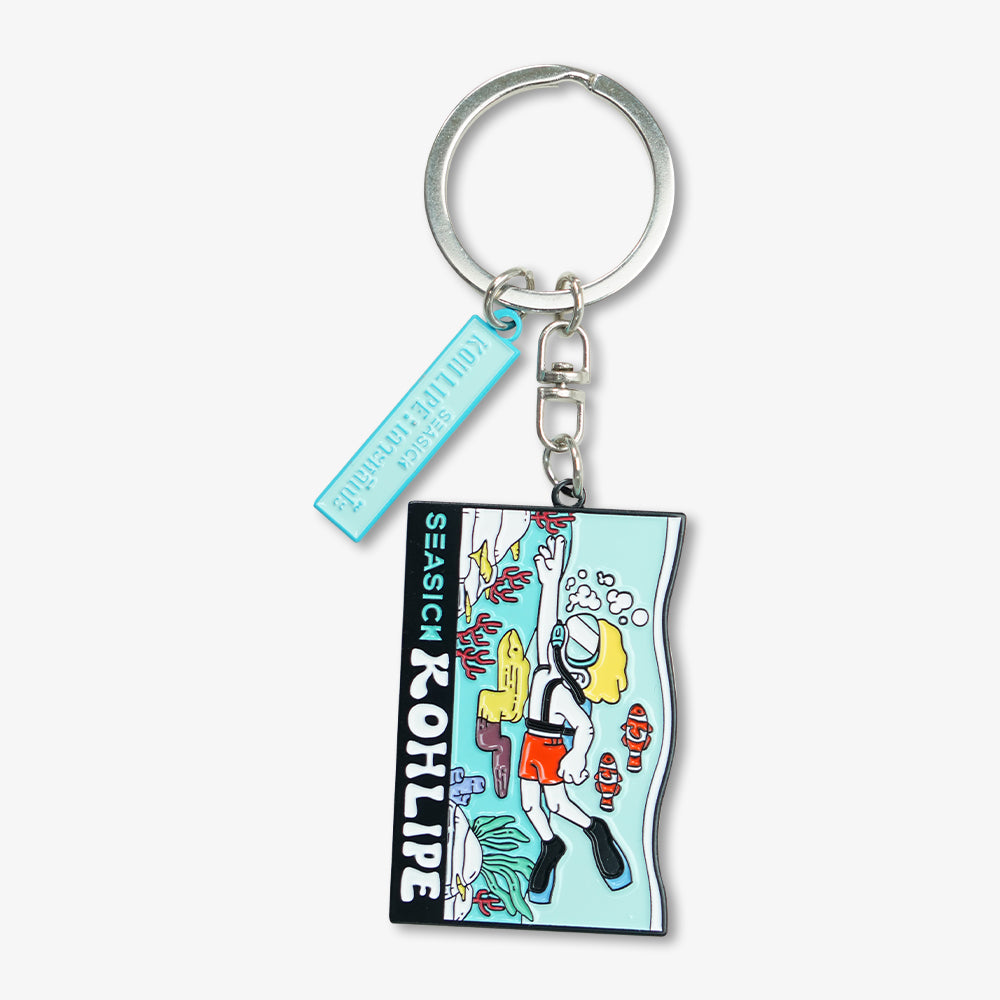 Metal enamel keychain with cartoon scuba diver underwater graphic, silver key ring and light blue engraved tag