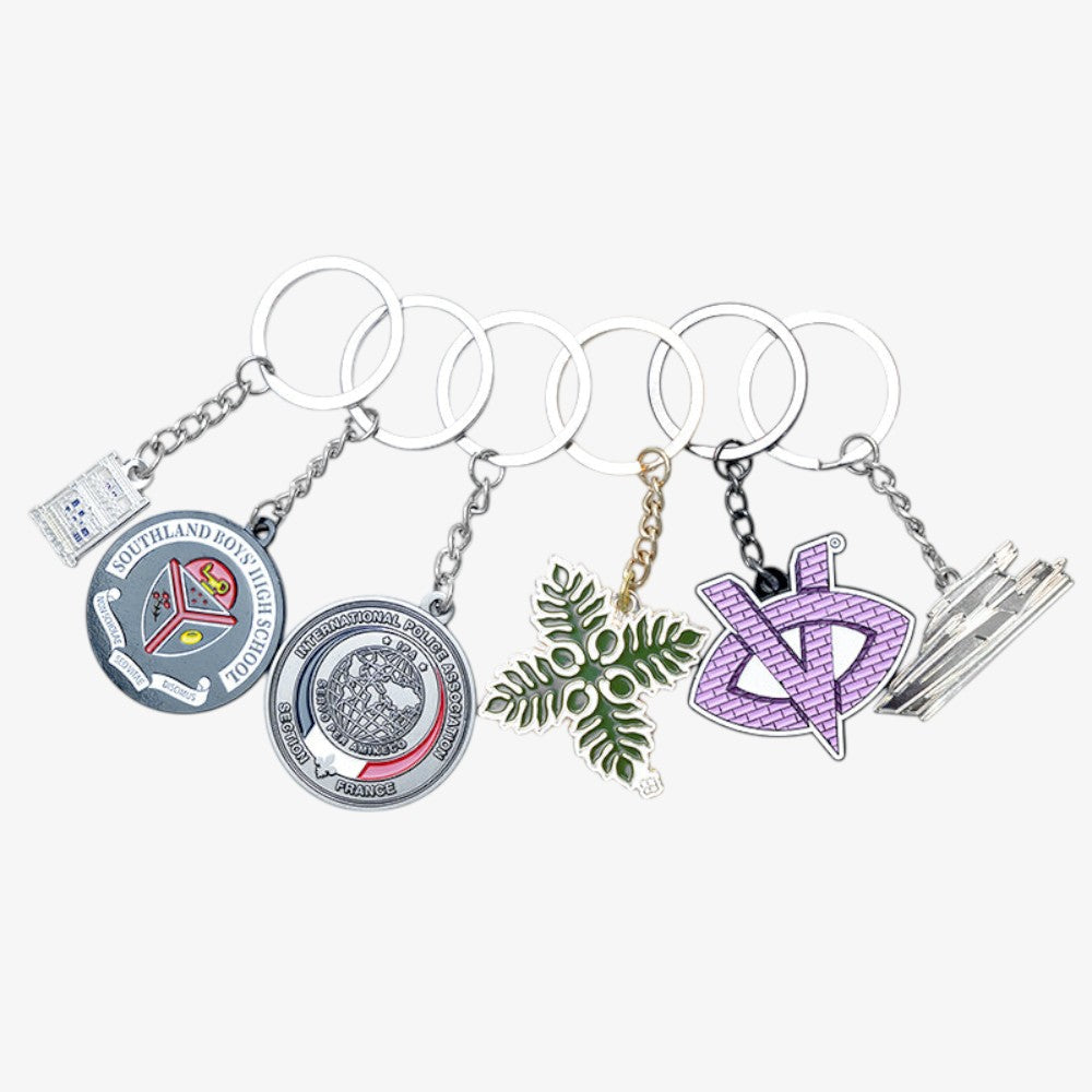 Metal Enamel Keychains with assorted custom colorful pendants of various unique patterns on plain white background