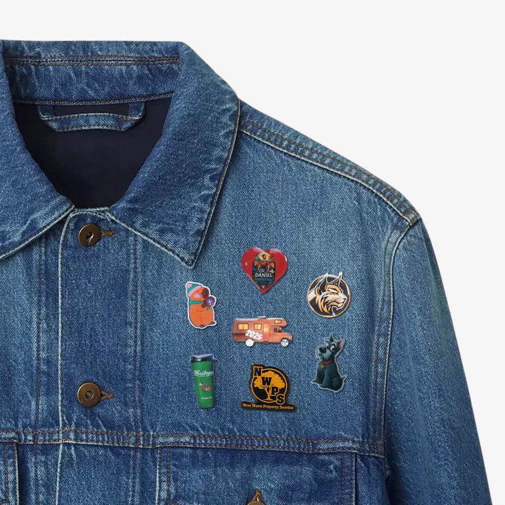 Photo dome pins in assorted shapes including heart, circle, and animal designs, featuring glossy resin finish and colorful artwork on a denim jacket