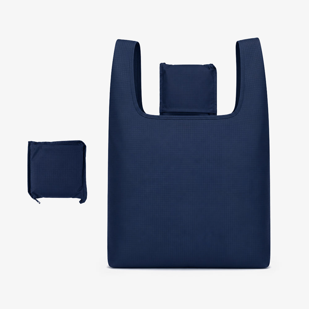 Navy blue grid-textured polyester foldable bag, showing full expanded tote and compact folded zipper pouch