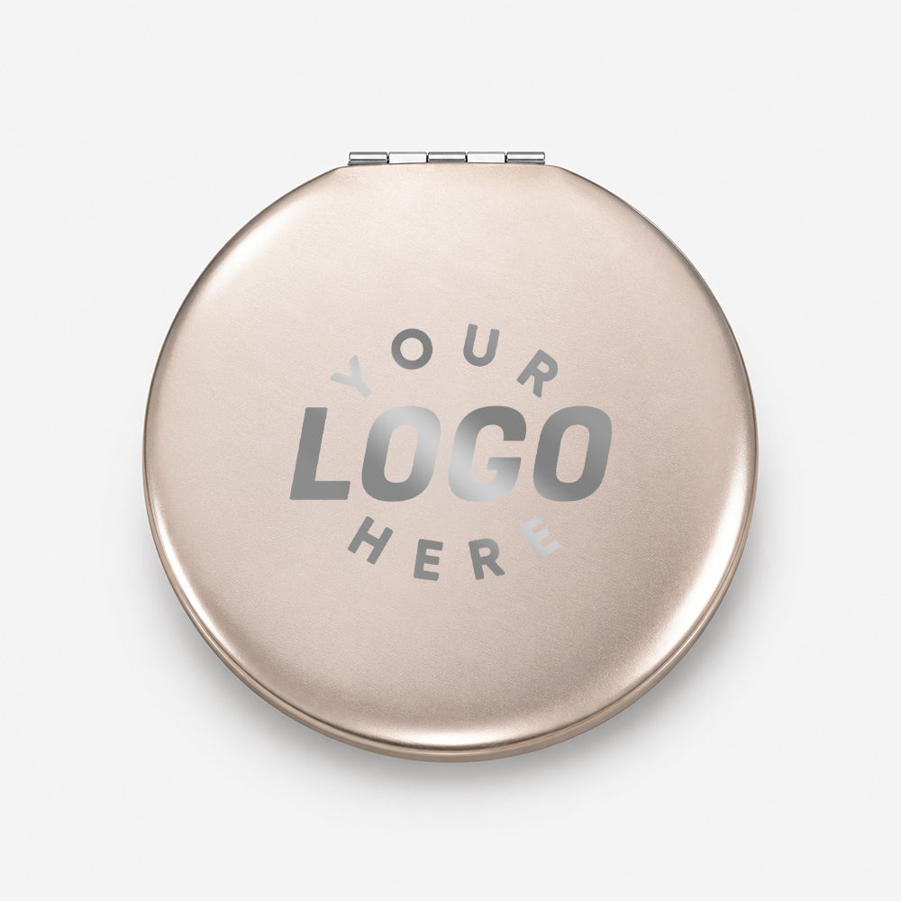 Compact round aluminum folding mirror with rose gold finish and hinge detail