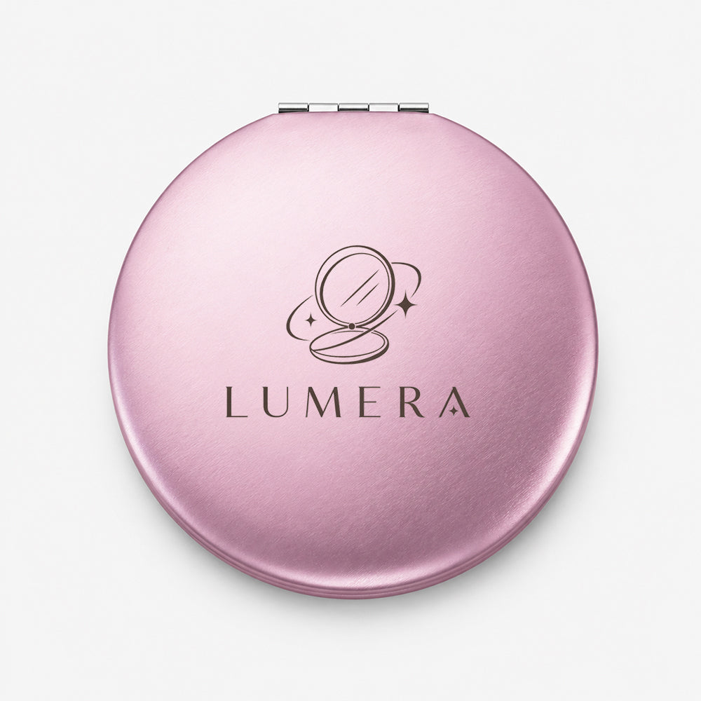 Compact round aluminum mirror in soft pink with brushed finish and hinge detail
