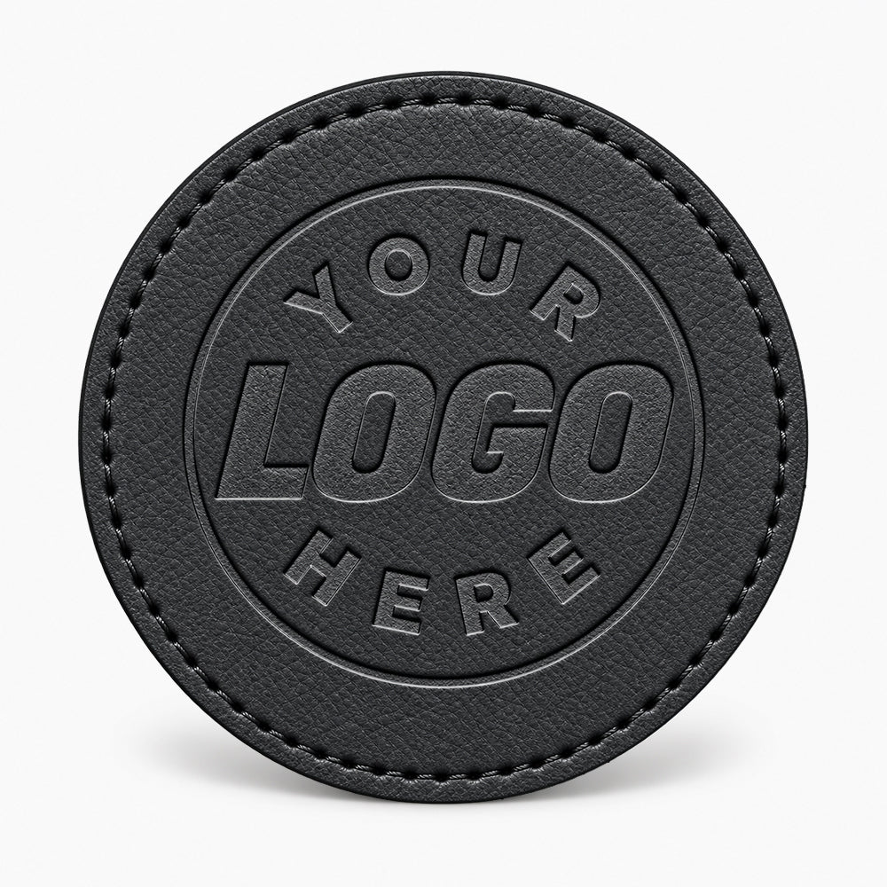Black circular leather coaster with stitched edge and debossed center design