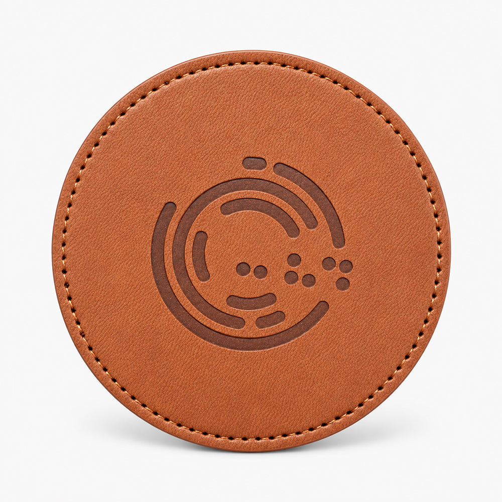 Round tan leather coaster with stitched edge and debossed circular pattern