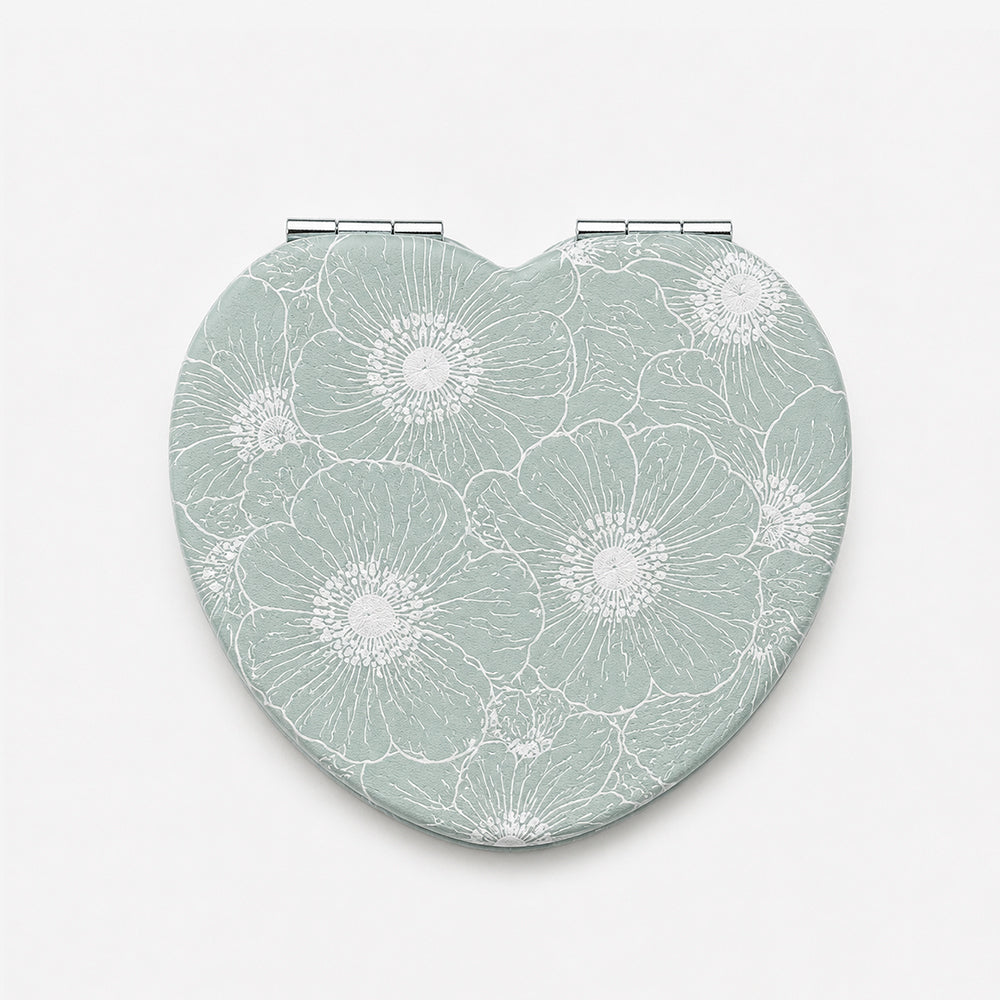 Heart-shaped folding compact mirror in mint green PU leather with white floral embossing and dual hinges
