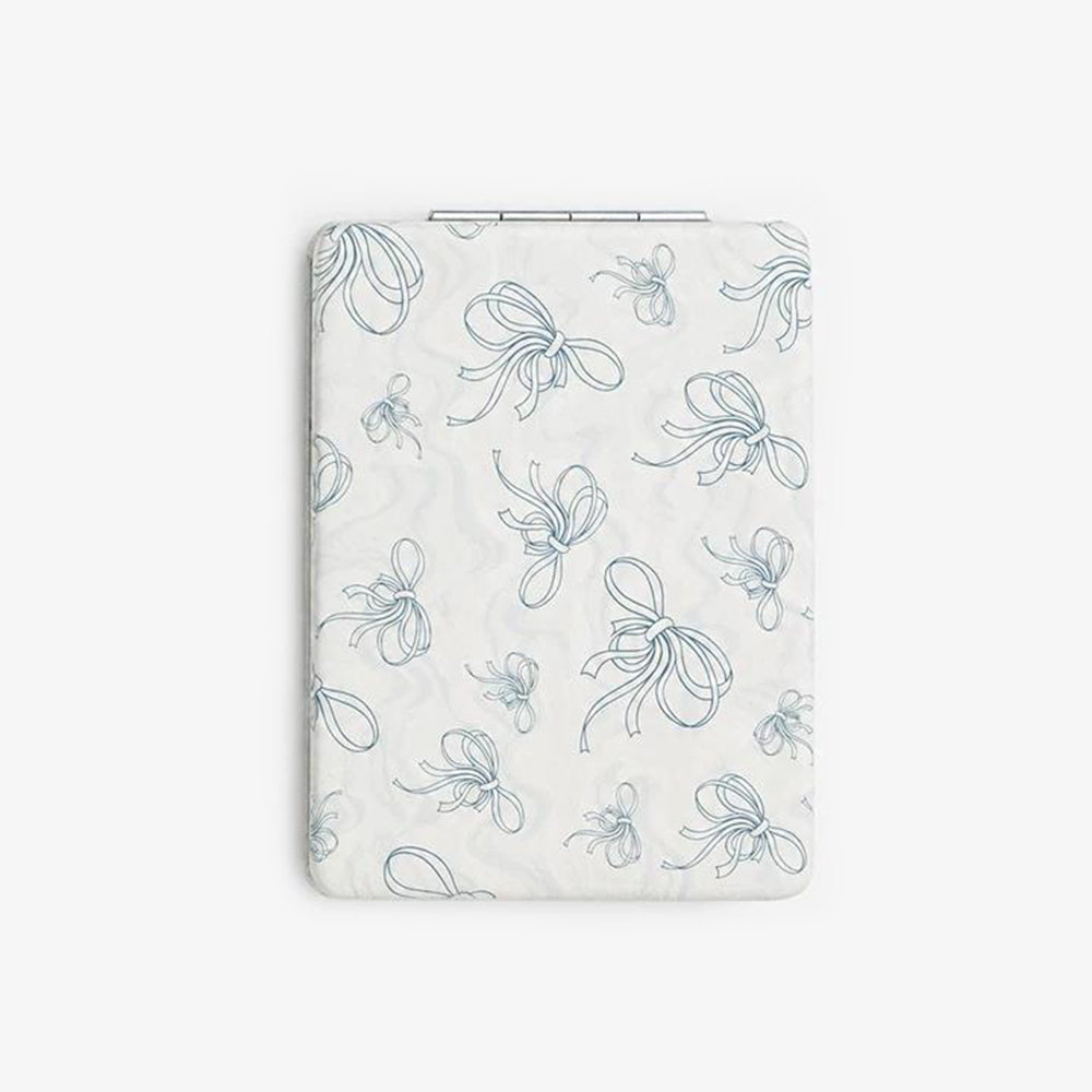Folding compact mirror with white PU leather cover featuring a delicate blue ribbon pattern and a slim metallic hinge