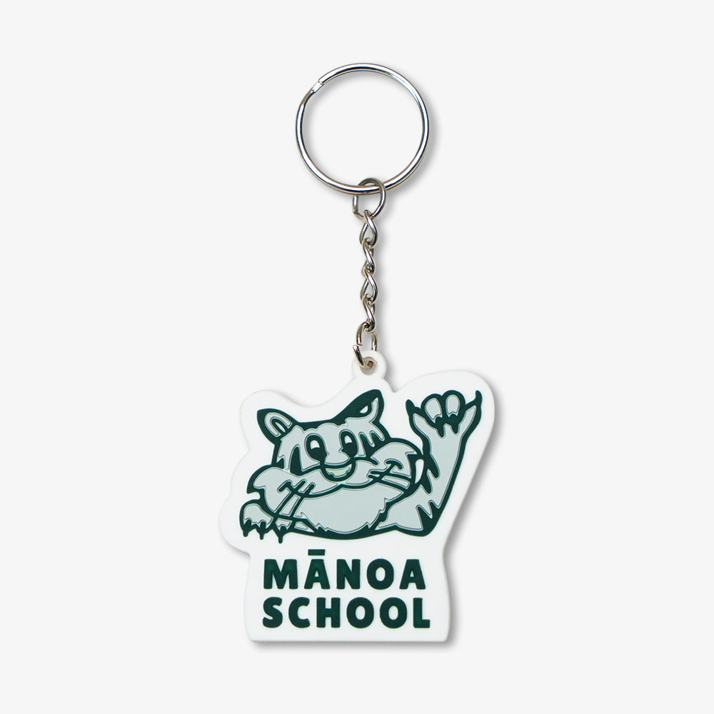 PVC rubber keychain featuring Manoa School waving cat mascot, white base with dark green print and silver metal key ring