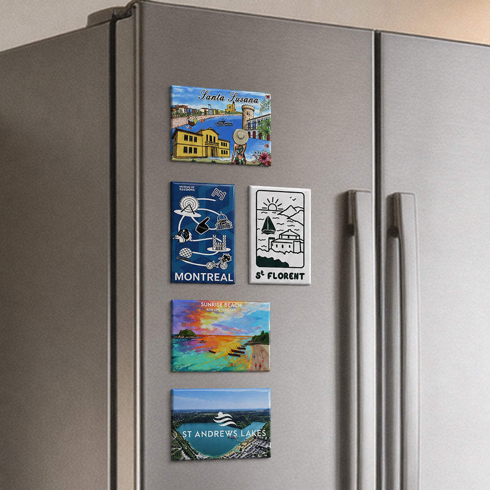 Rectangle fridge magnets with various scenic travel destination prints attached on a stainless steel refrigerator door