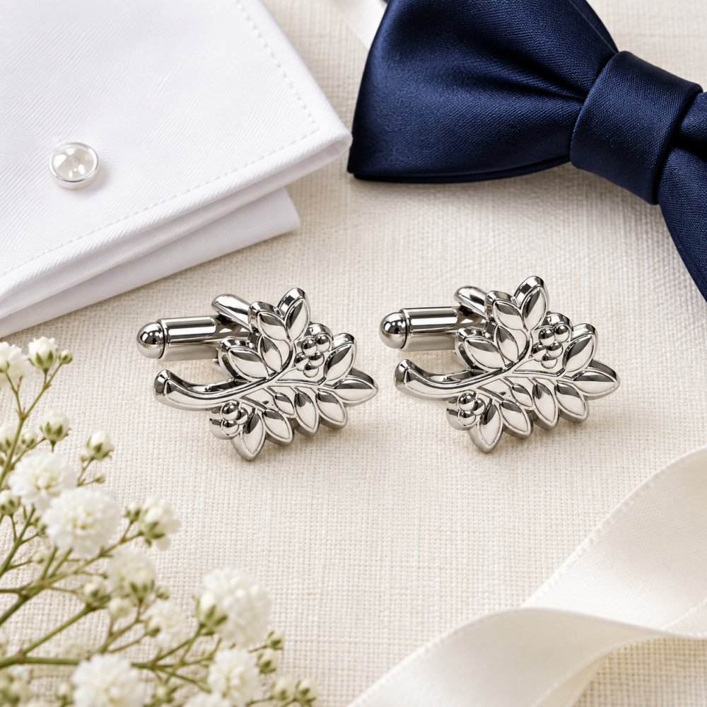 Silver-toned leaf-patterned cufflinks with soft enamel detailing and polished metal stems