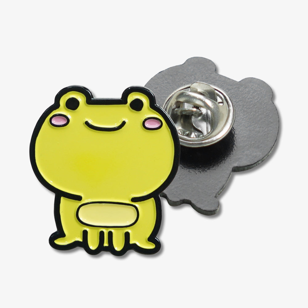 Cute yellow smiling frog soft enamel pin with pink cheeks, showing front cartoon design and metal clutch back