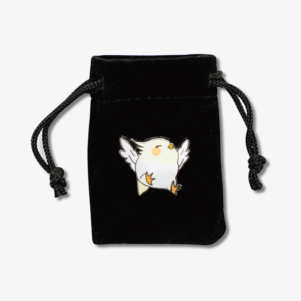 Black velvet drawstring bag adorned with a cute cartoon white bird enamel pin on the front