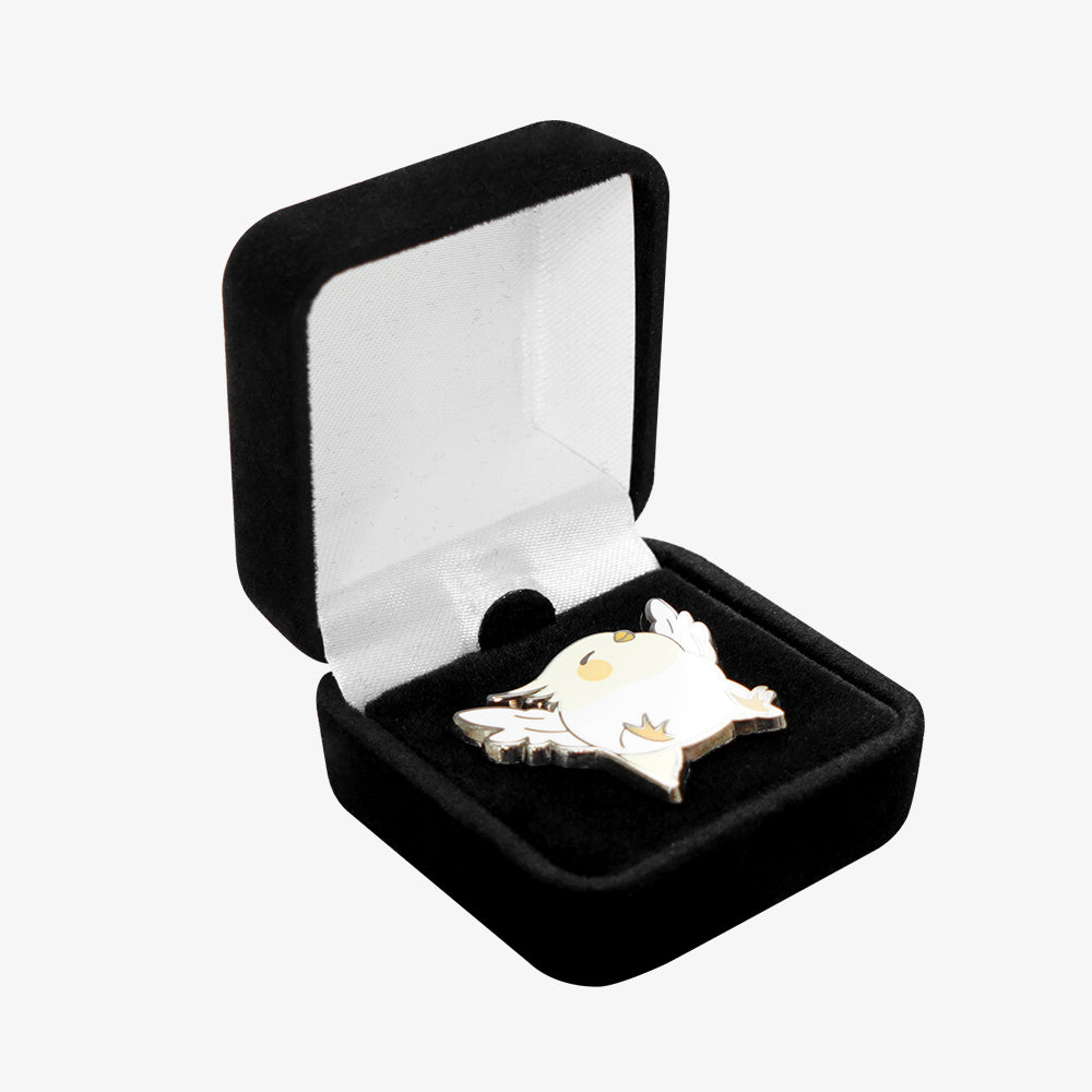 Black velvet pin box with white satin lining, holding a cute cartoon bird enamel pin inside