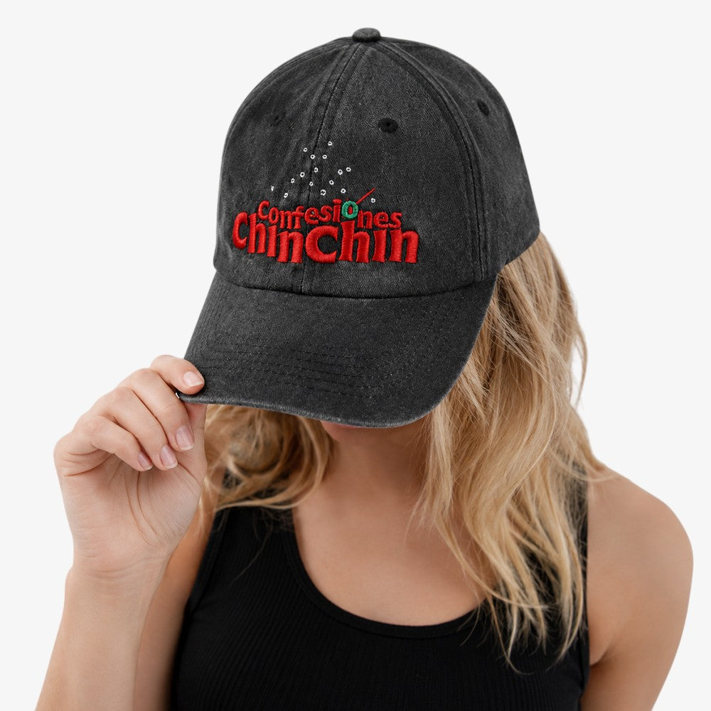 Washed black baseball cap with red embroidered text and small white dot details on the front panel