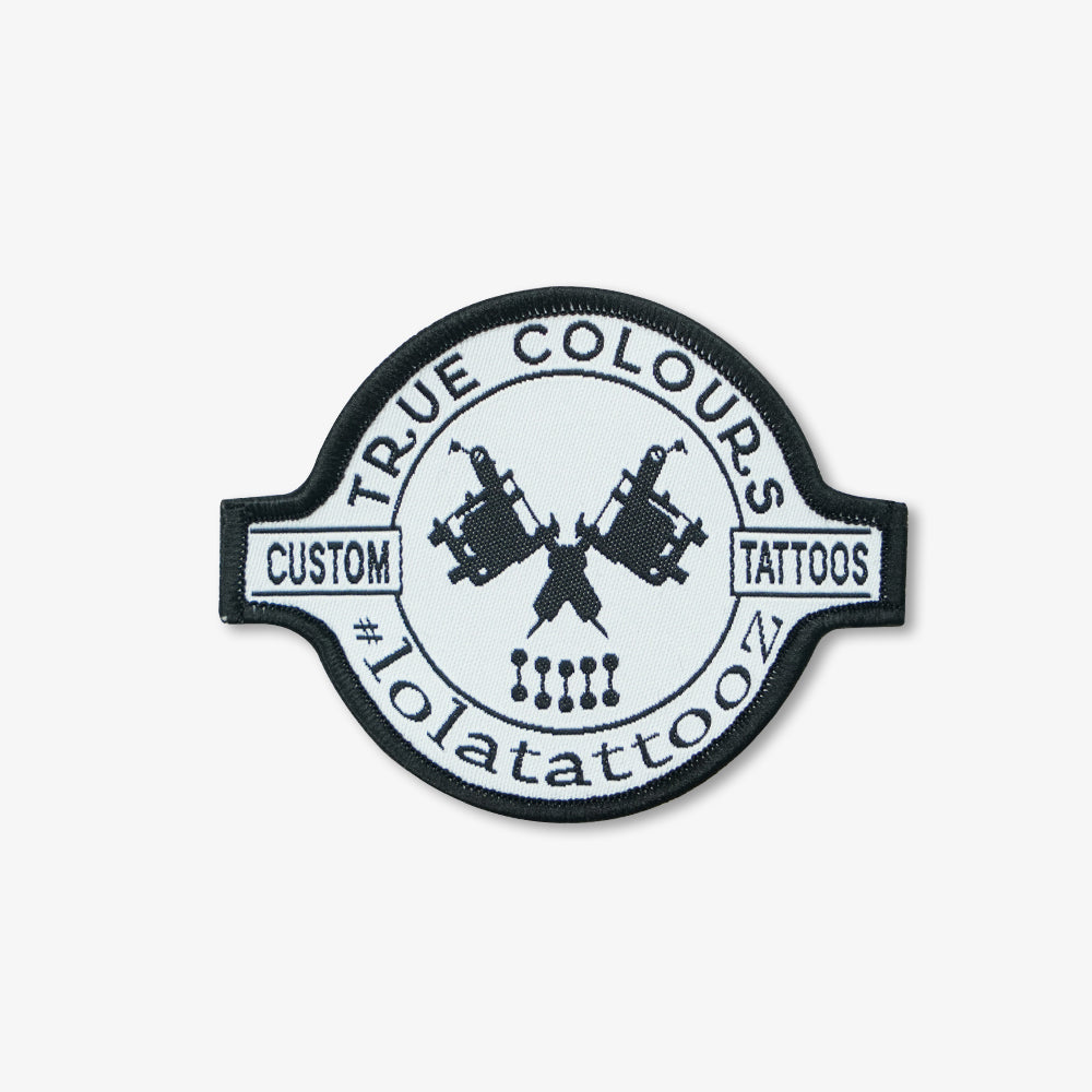 Woven patch with black embroidered border, monochrome custom tattoo studio logo design on white woven base